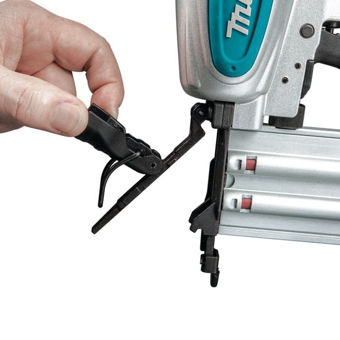 A close-up of a hand opening the tool-free jam release latch on the nose of the Makita AF506 brad nailer.