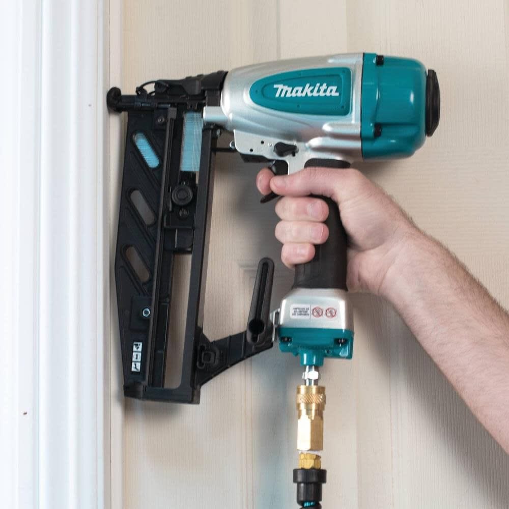 Action shot of a woodworker accurately driving a fastener into white door casing trim with the Makita AF601 air powered 16 gauge straight finish nailer.