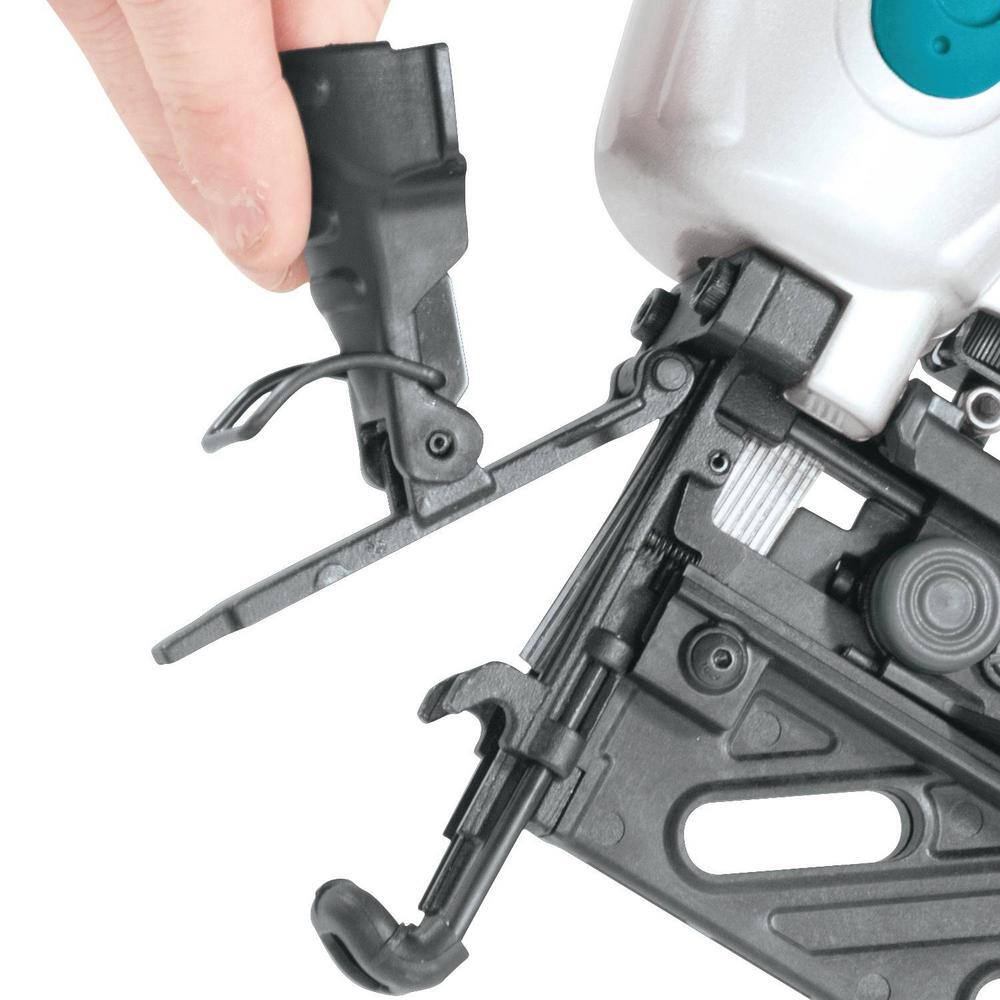 Close-up of a thumb pressing the built-in air duster button on the Makita AF601 finish nailer to instantly clear dust and debris from a woodworking surface.