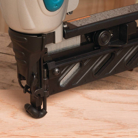Close-up of a nail gun on a wooden surface