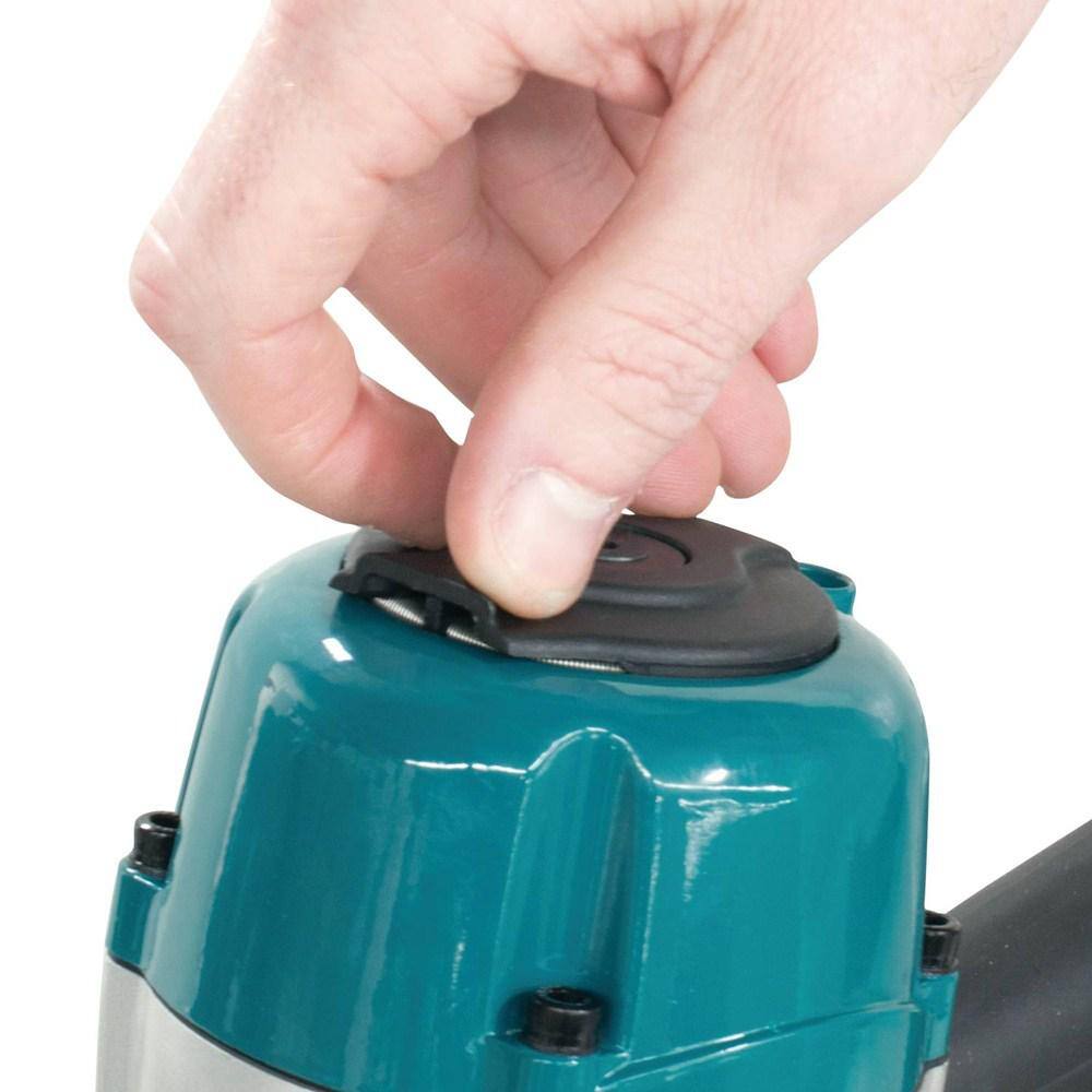 Hand closing a black lid on a teal machine with a white background