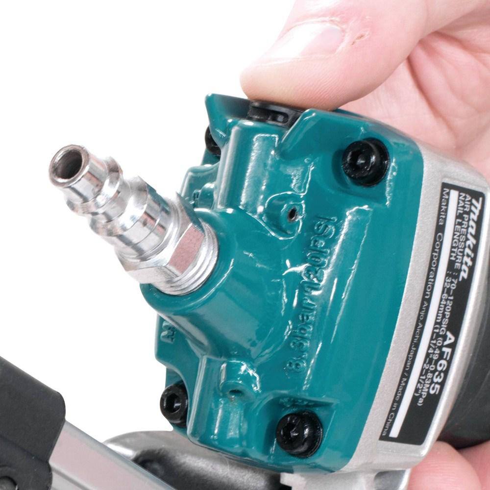 Teal and silver router bit held in a hand against a white background