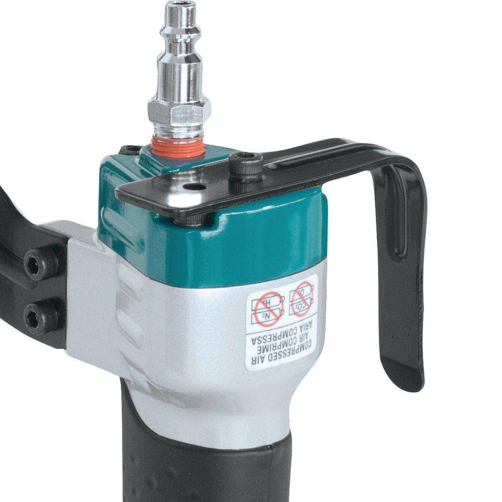 Close-up action shot of a hand operating the Makita AT1150A medium crown stapler, demonstrating the ergonomic rubberized handle and the single sequential firing mode.