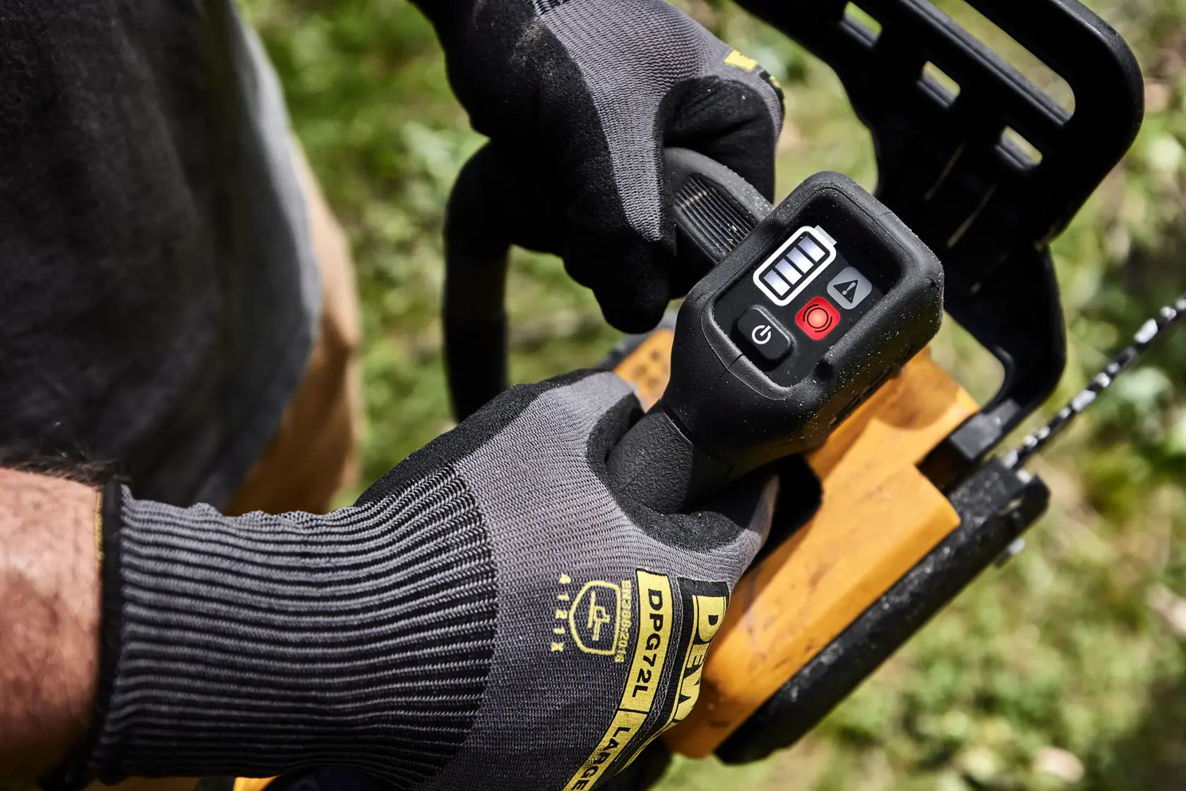Detail view of the ergonomic top handle and integrated LED dashboard of the DEWALT cordless chainsaw, designed for maximum maneuverability and user control during vertical climbing applications.