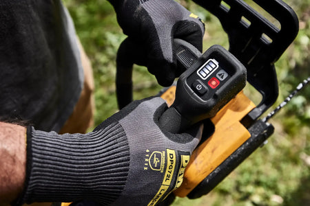 Detail view of the ergonomic top handle and integrated LED dashboard of the DEWALT cordless chainsaw, designed for maximum maneuverability and user control during vertical climbing applications.