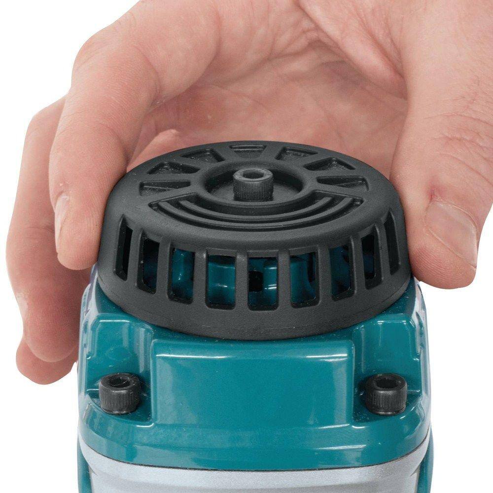 Hand inspecting the motor housing and vented cap of a Makita pneumatic tool, highlighting durable construction and cooling design used in the AT2550A stapler kit.