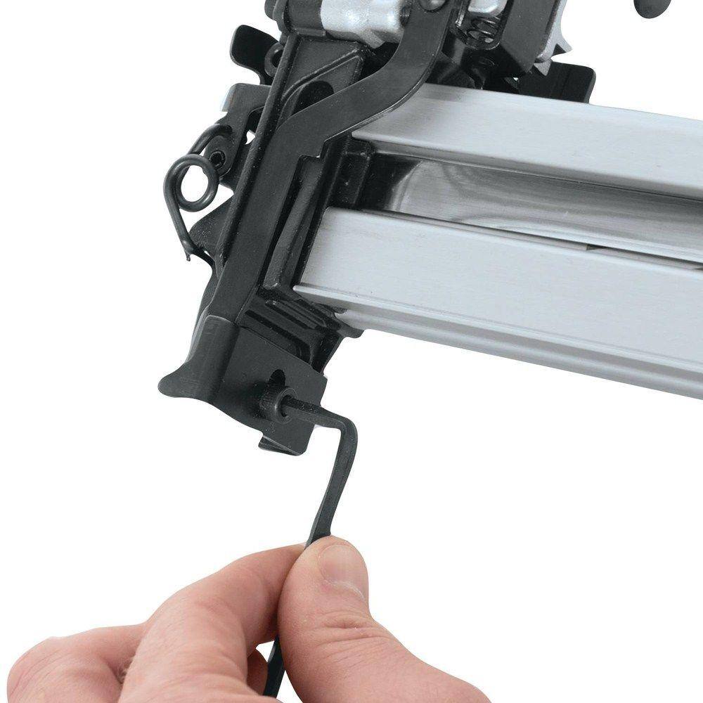 User adjusting a screw on a Makita pneumatic stapler using an Allen wrench, demonstrating routine maintenance and setup for the AT2550A wide crown stapler.