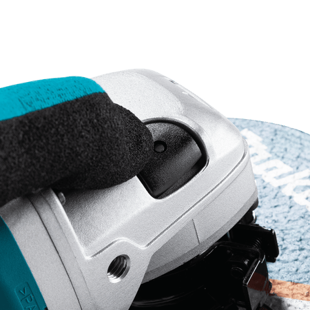 Close-up of the spindle lock button on the Makita angle grinder head for secure, efficient accessory changes.