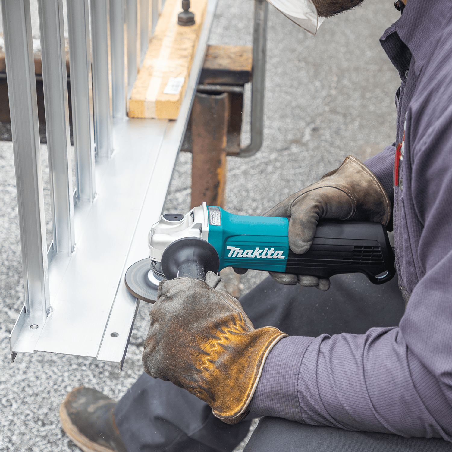 Tradesman smoothing aluminum frame welds using a 4-1/2-inch grinding wheel mounted on the Makita GA4553R angle grinder.