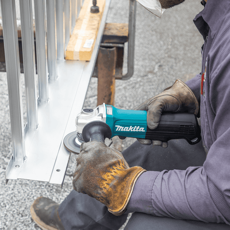 Tradesman smoothing aluminum frame welds using a 4-1/2-inch grinding wheel mounted on the Makita GA4553R angle grinder.