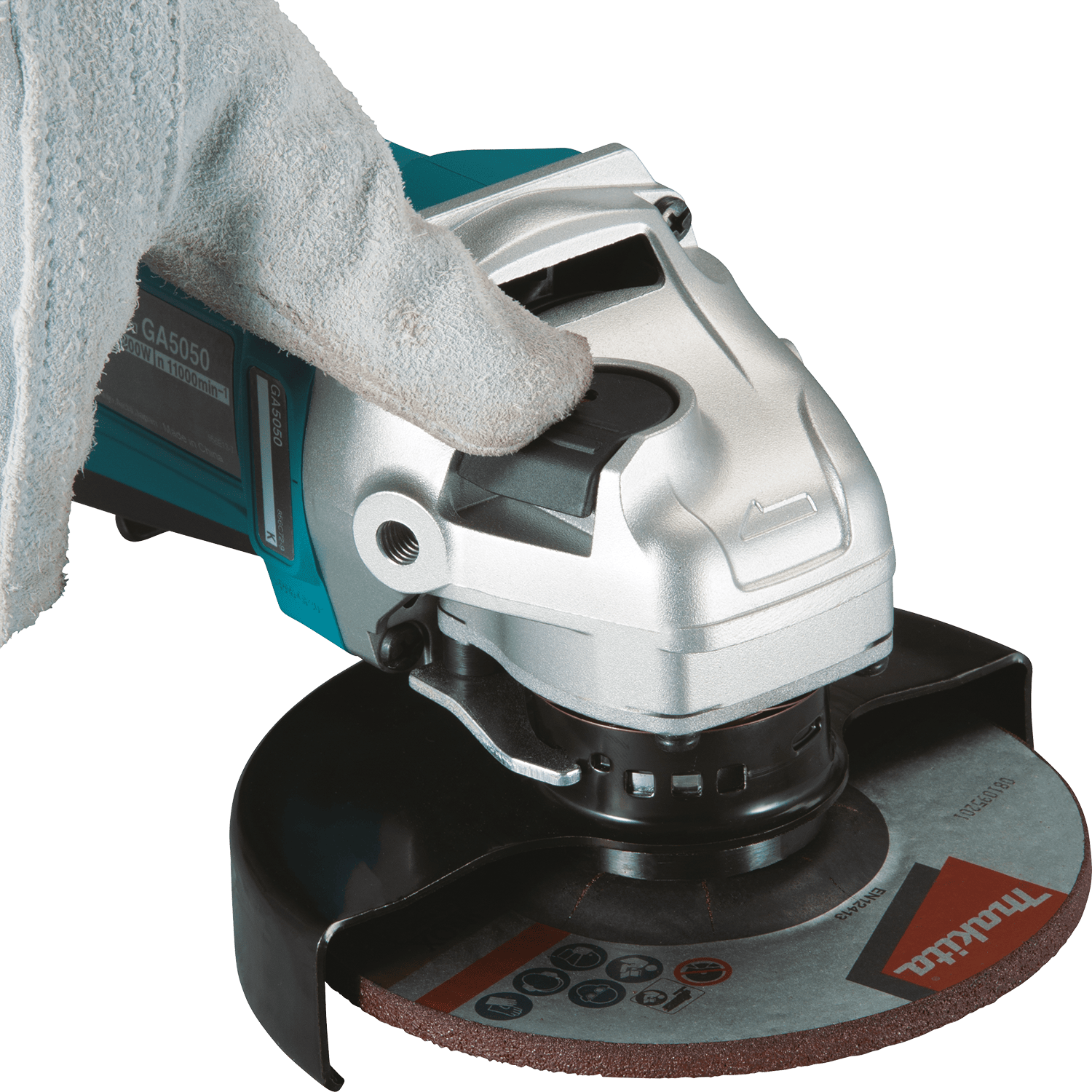 Gloved thumb depressing the large spindle lock button on the cast aluminum gear head of the Makita GA4553R angle grinder.