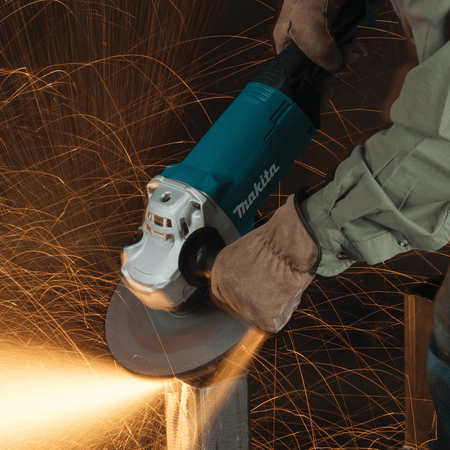 Fabricator using the 15.0A Makita GA9060 9-inch angle grinder at 6,600 RPM to bevel a heavy steel box tube.