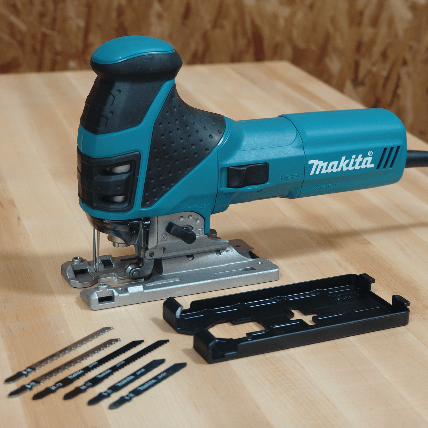 Makita 4351FCT barrel grip jig saw kit displayed with six T-shank blades and a non-marring shoe cover plate for tear-out free finish cuts.
