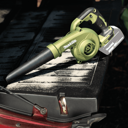 Makita ADBU05Z 18V LXT Outdoor Adventure blower resting on a dusty pickup truck tailgate to demonstrate mobile jobsite bed cleanup.