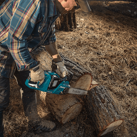 Forester bucking a large pine log using the Makita XCU04PT 36V 16-inch brushless chainsaw operating at 3,940 FPM chain speed.