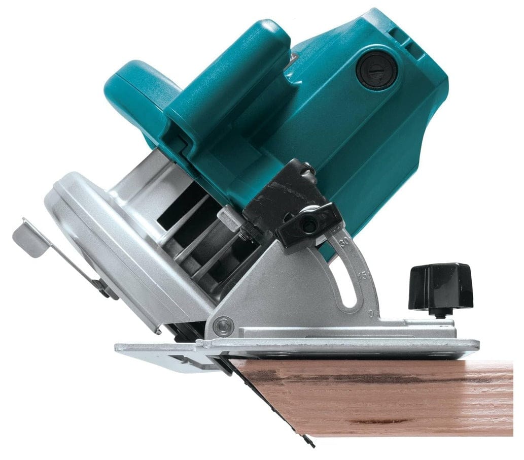 Makita 5007F circular saw tilted on its bevel adjustment plate executing an angled cut through structural dimensional lumber.