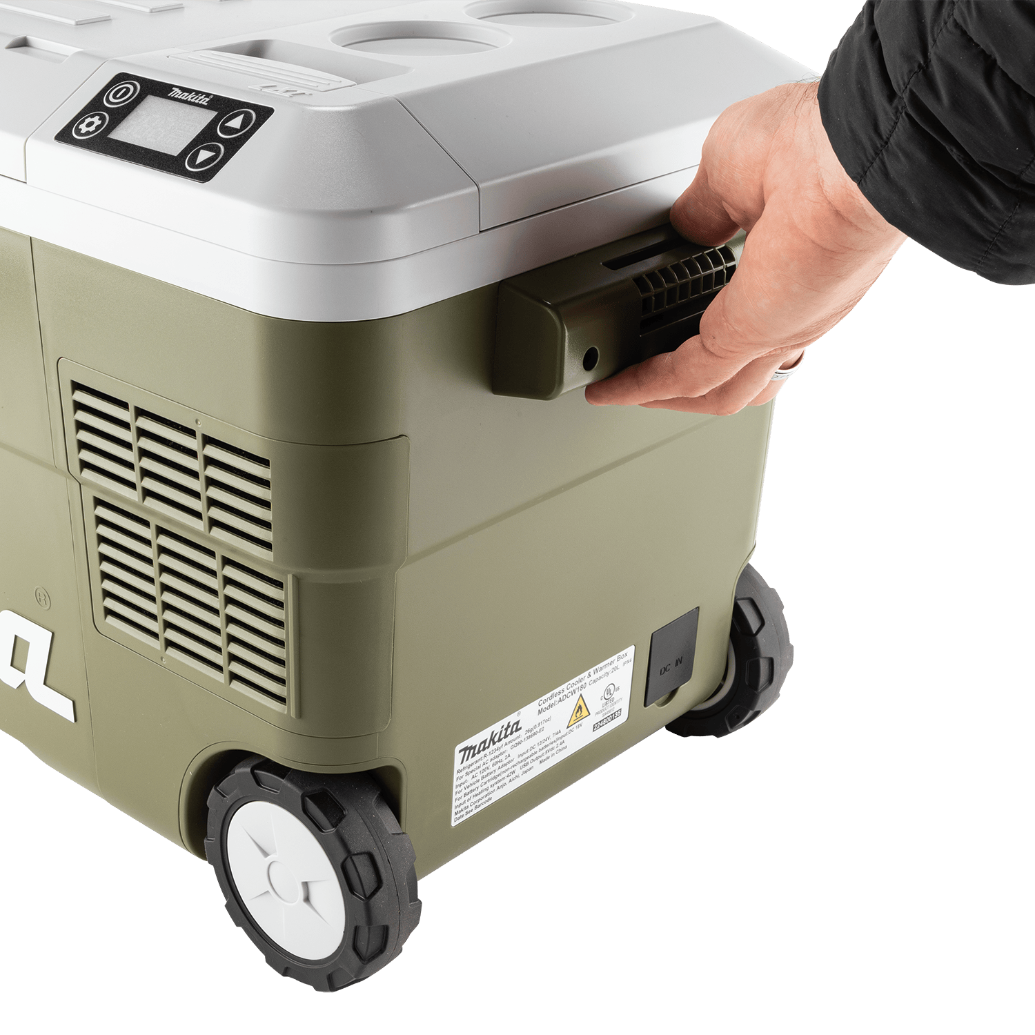 Operator pulling the Makita ADCW180Z 21-quart cooler across a jobsite using its side transport handle and 3-15/16-inch rolling wheels.