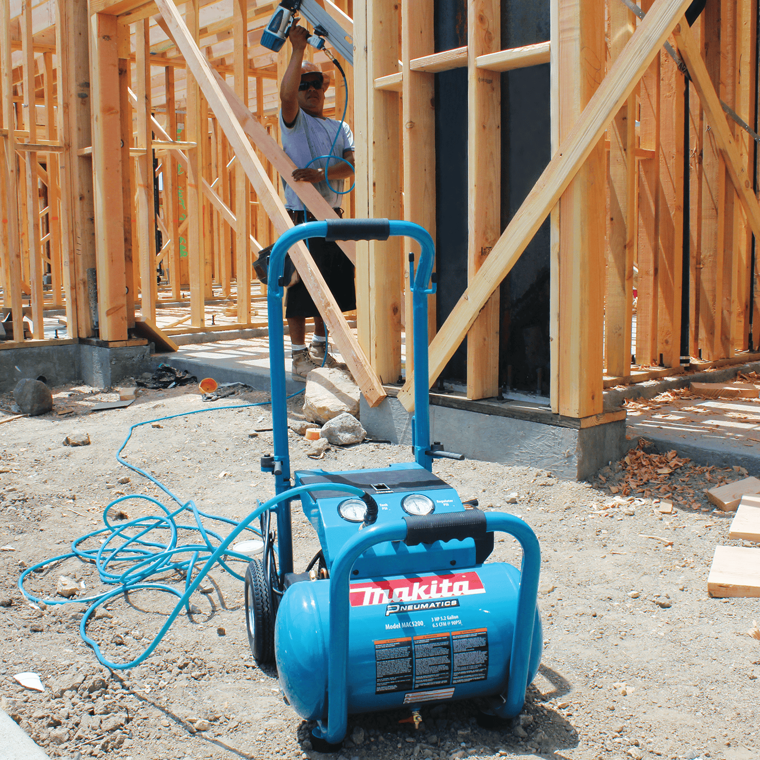 Makita MAC5200 5.2-gallon compressor delivering 6.5 CFM at 90 PSI to power overhead residential framing nailer work.