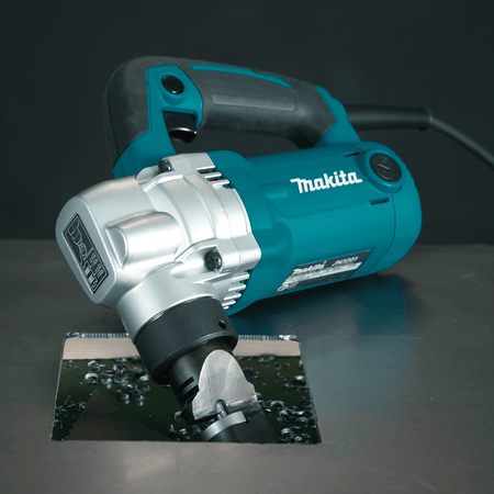 Makita JN3201 10-gauge nibbler completing a square internal cutout in sheet metal showing downward chip disposal beneath the work surface.