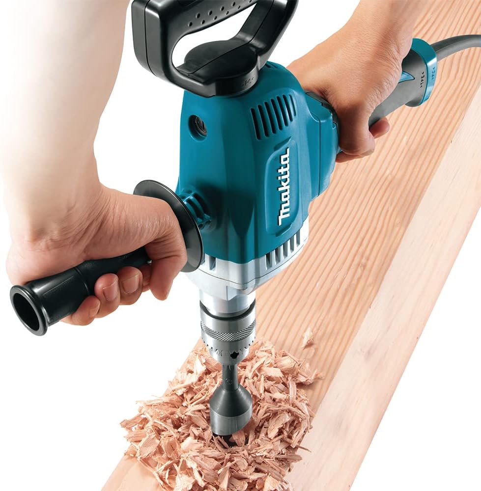 Tradesman boring a large clearance hole through a wooden beam using a self-feed bit chucked into the Makita DS4012 spade drill.