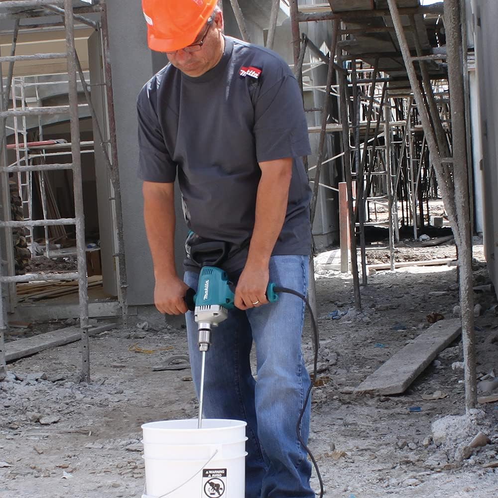 Construction worker blending drywall joint compound in a bucket using the high-torque Makita DS4012 corded mixing drill.