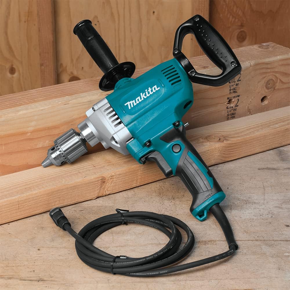 Makita DS4012 1/2-inch spade handle drill resting on framing timber, showing the heavy-duty cord, keyed chuck, and side handle.