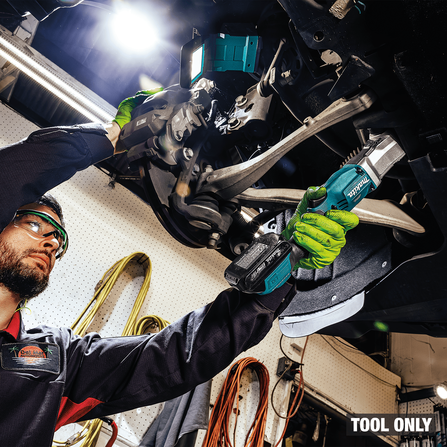 Automotive technician uses the Makita XLT03Z 3/8-inch angle impact wrench to access tight suspension bolts under a vehicle.