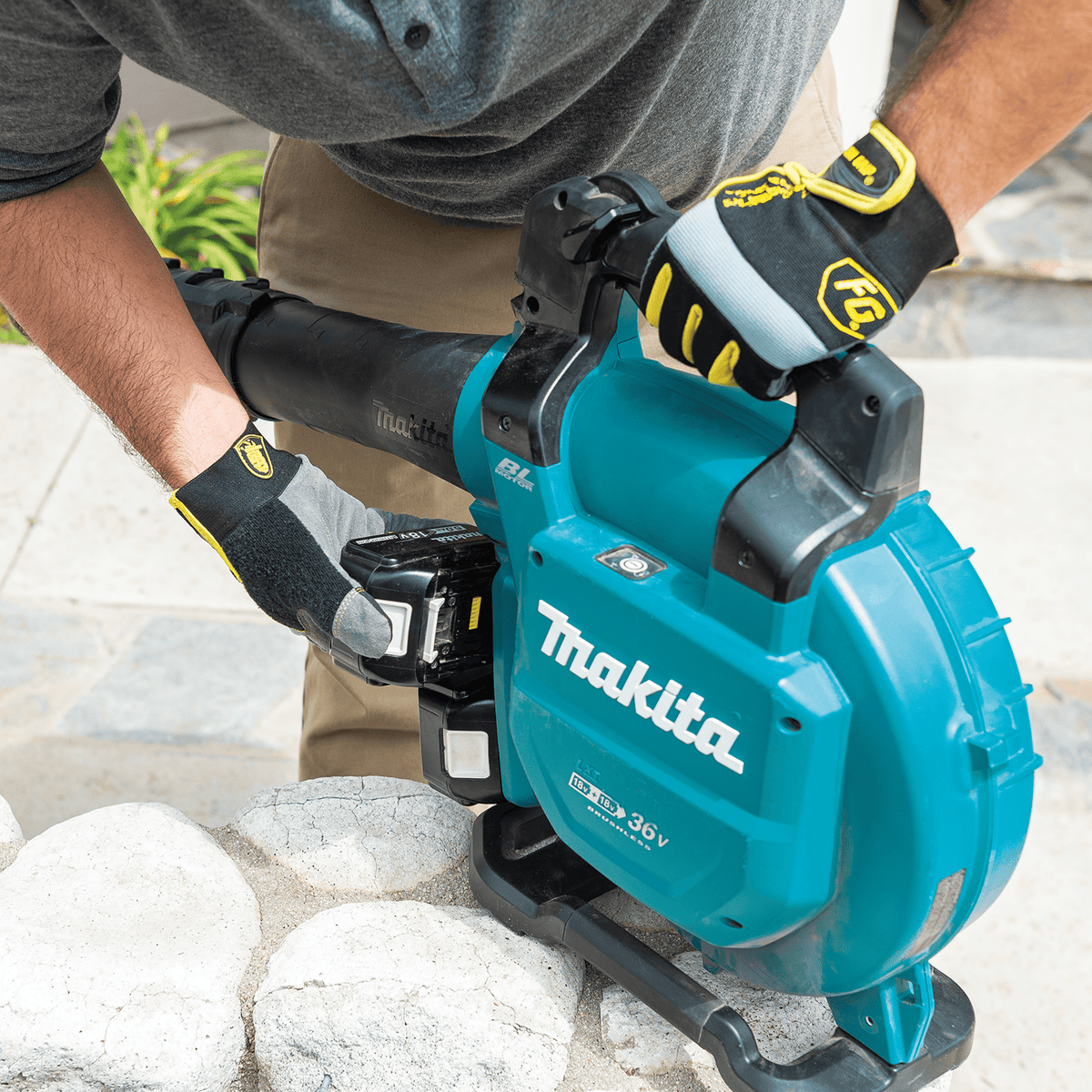 Technician inserting dual 18V batteries into the Makita XBU04PTV cordless tool housing.