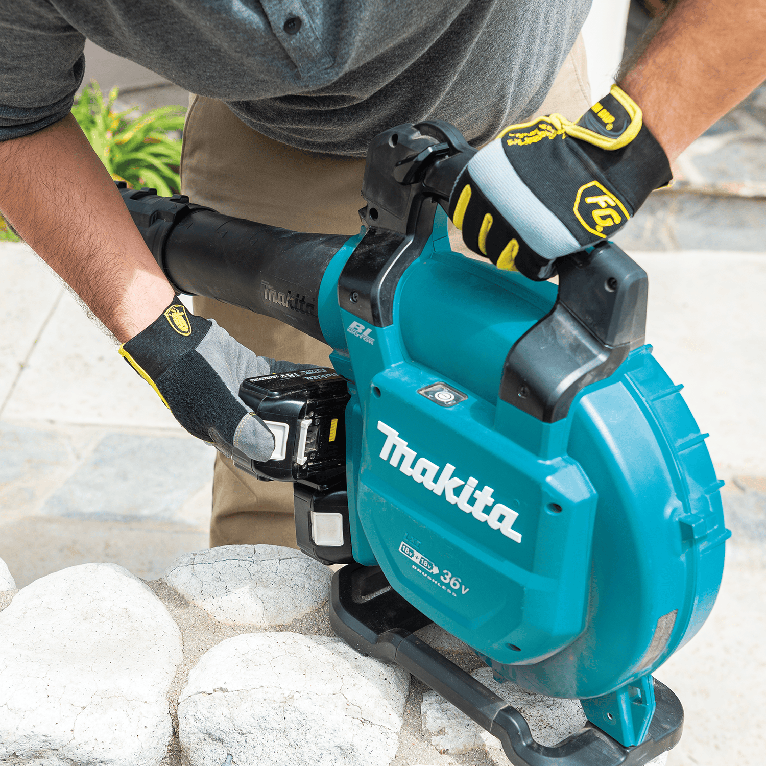 Technician inserting dual 18V batteries into the Makita XBU04PTV cordless tool housing.