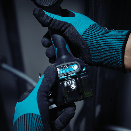 Technician wearing protective gloves selecting quick-shift electronic speed modes on the base panel of a Makita XDT20 impact driver.