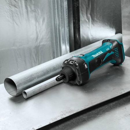 Makita XDG02Z cordless die grinder resting on a steel fabrication workbench alongside metal tubing for internal deburring jobs.
