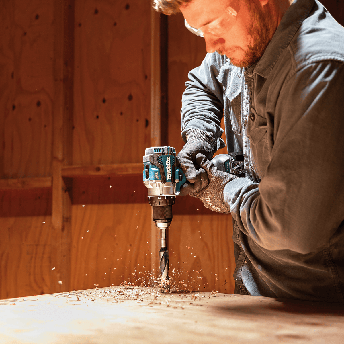 Tradesman using the Makita XFD16Z 18V brushless driver-drill with a spade bit to bore clean holes through wood subflooring.