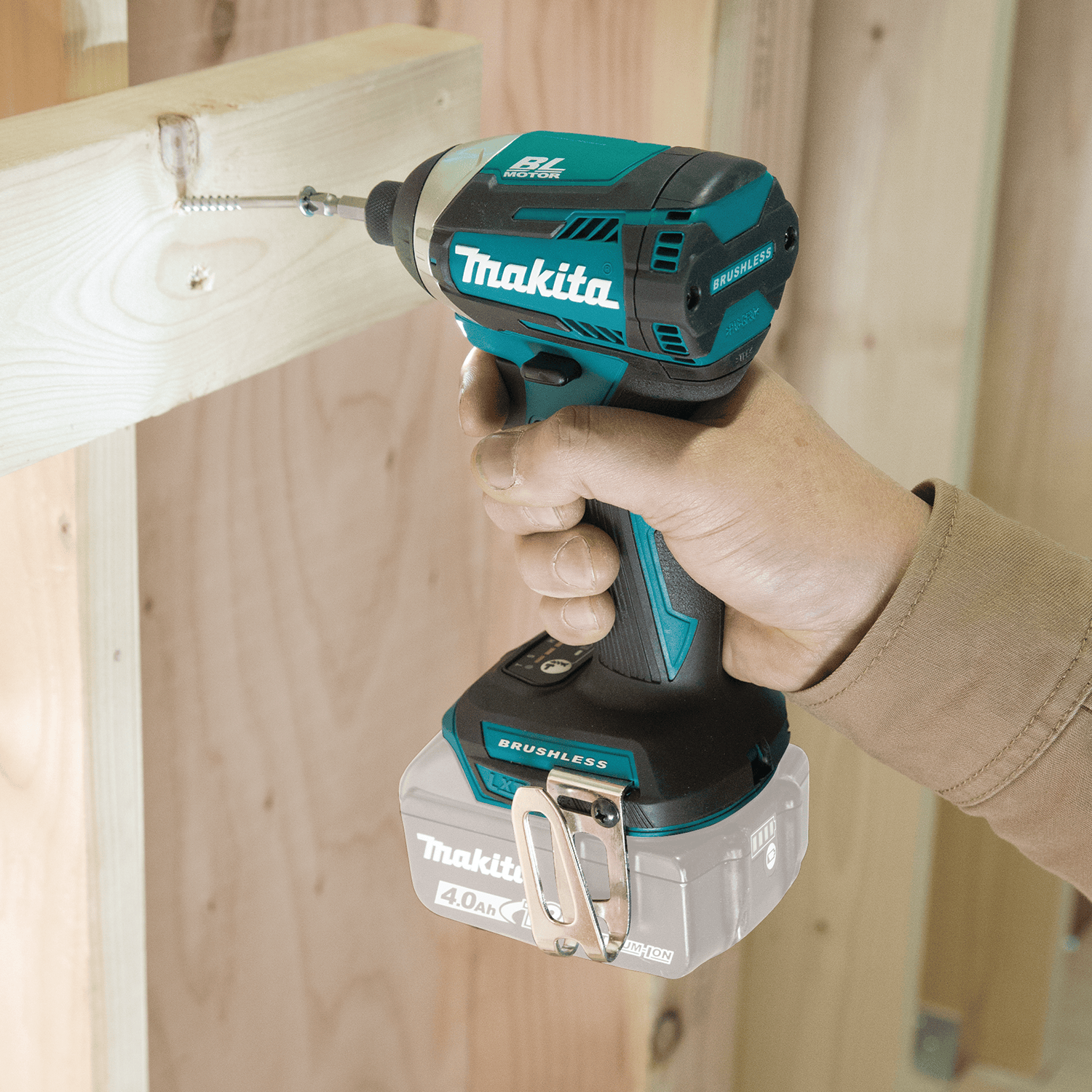 Fastening wood framing screws with the compact Makita XDT14Z 18V cordless brushless impact driver on a construction site.