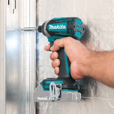 Worker uses the Makita XDT14Z 1/4-inch hex impact driver to drive self-tapping fasteners into commercial steel framing.