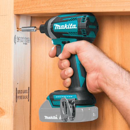 Compact 4-5/8-inch Makita impact driver fits between narrow 2x4 wood wall studs to drive fasteners in tight corners.