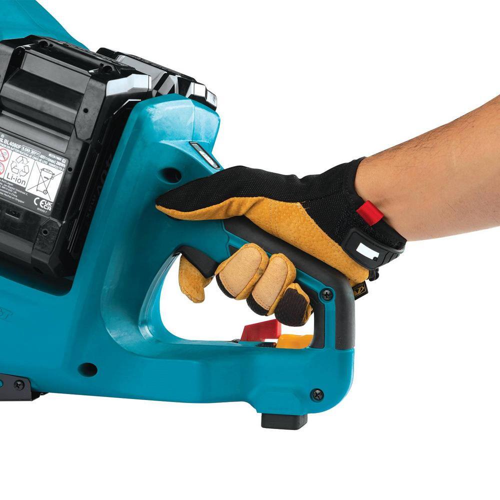 Close-up perspective of a worker wearing leather reinforced safety gloves wrapping their fingers around the ergonomic rubberized D-handle grip of the Makita saw, depressing the dual-action lock-off power switch trigger mechanism.