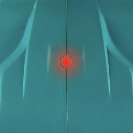 Close-up detail view of the round orange electronic overload protection indicator light glowing bright red on the top surface of the teal plastic motor housing frame.