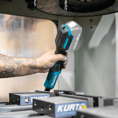Operator holding the ergonomic rubberized handle of the Makita XRW01Z ratchet during overhead mechanical equipment maintenance.
