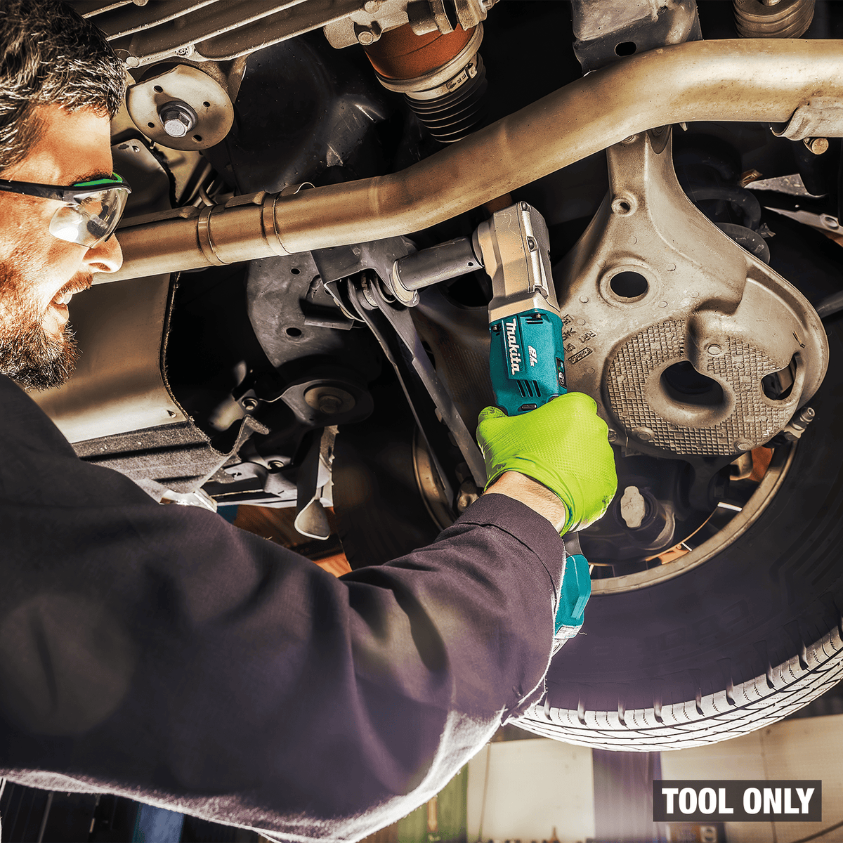 Mechanic removing rear suspension control arm bolts with the Makita XLT05Z right angle impact wrench under a vehicle lift.
