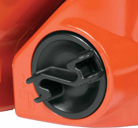 Detail view of the black oil tank cap located near the front handle of the orange chainsaw housing.