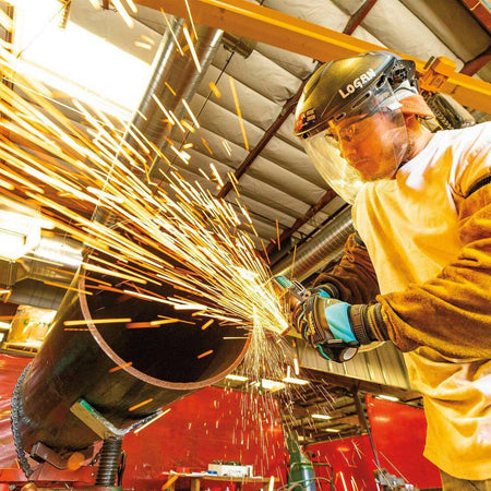 Action shot of the Makita 40V XGT cordless grinder cutting through a thick metal workpiece, producing sparks and showcasing the high-speed efficiency and safety of the integrated electric brake system.