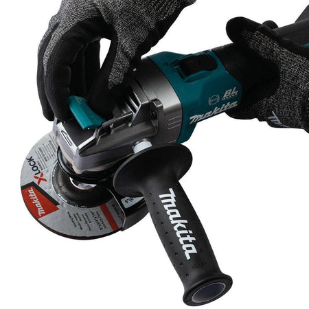 Action shot of a worker in protective gear pulling the X-LOCK release lever to demonstrate the rapid, tool-free removal of a 5-inch wheel from the Makita XGT angle grinder.