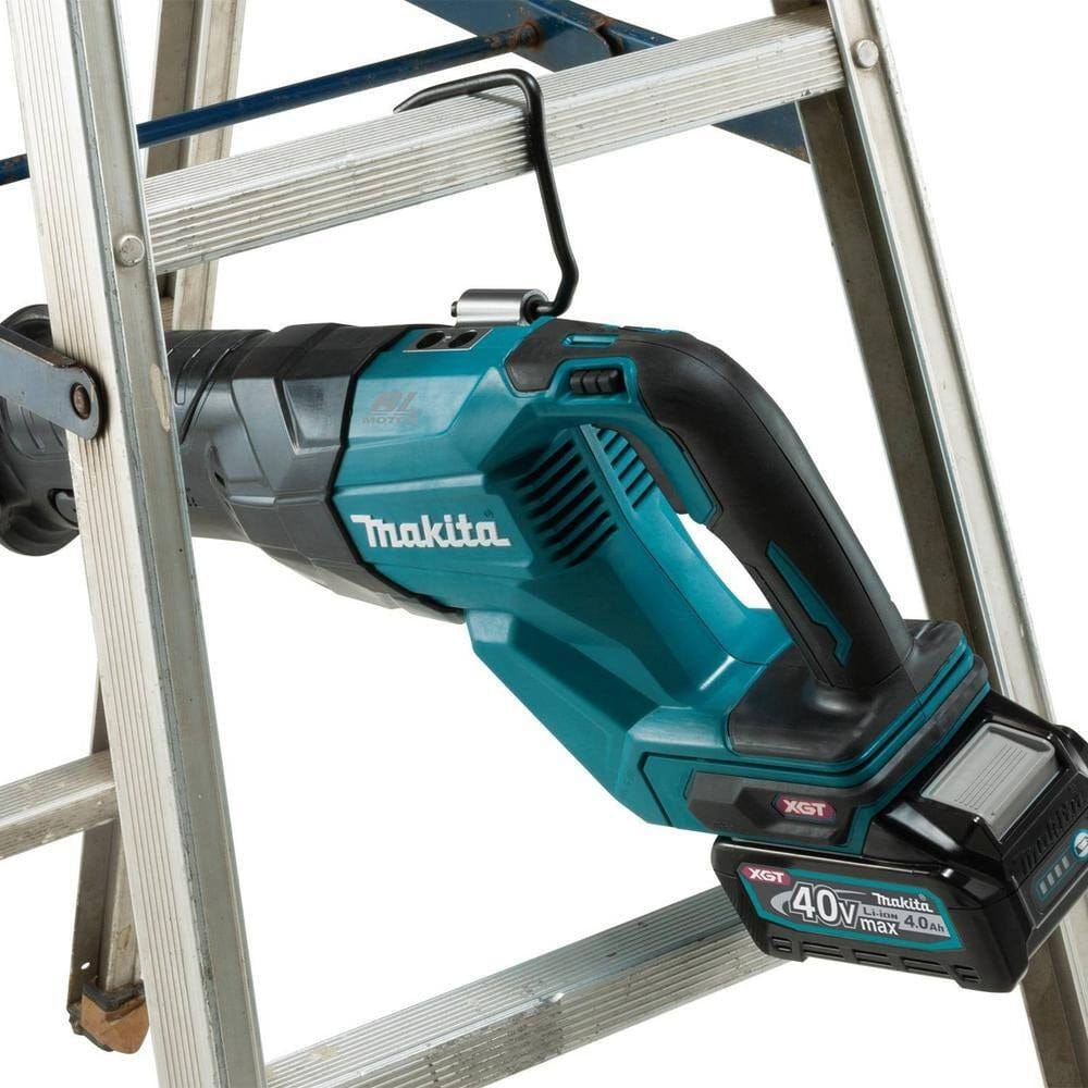 An action photograph of the Makita 40V Max XGT reciprocating saw hanging from a metal ladder by its integrated retractable tool hook, demonstrating convenient jobsite storage.