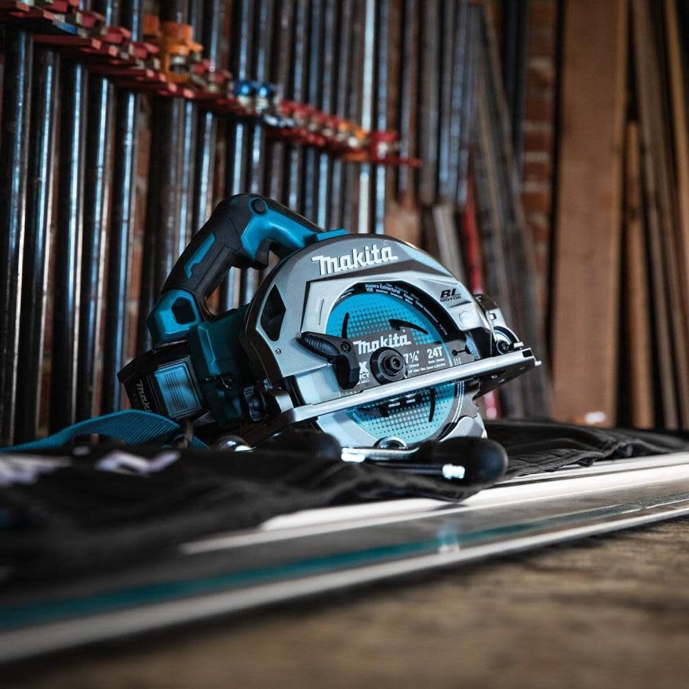 Low angle studio shot of the circular saw sitting on a guide rail track with a blurred workshop background.