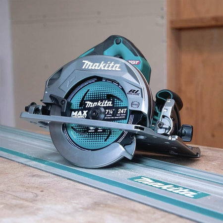 Action shot of the circular saw resting on a guide rail track on top of a wooden workpiece, highlighting the base compatibility.