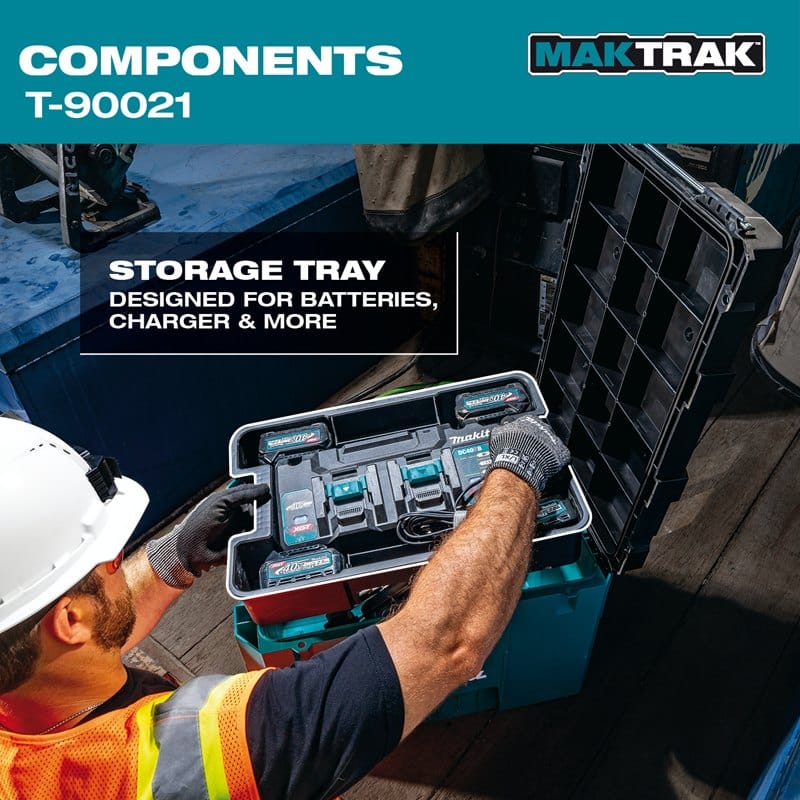 A worker placing a specialized storage tray filled with power tool batteries and a charger into the Makita T-90021 large tool box.