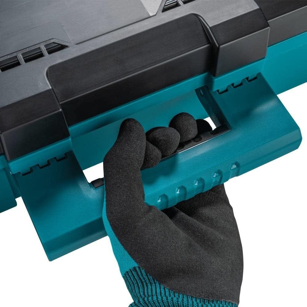 A close-up shot of a tradesperson in a safety glove using the robust comfort-grip carrying handle on the Makita MAKTRAK tool box, designed for easy transportation of up to 75 lbs of equipment.