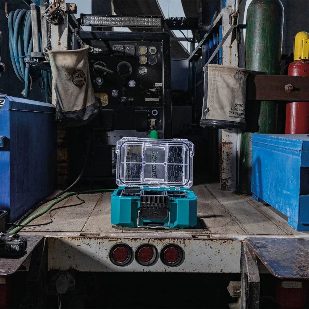 The Makita MAKTRAK T-90065 deep compact organizer shown open and filled with removable bins on a professional industrial surface, demonstrating its use as an advanced modular storage solution for trade professionals.