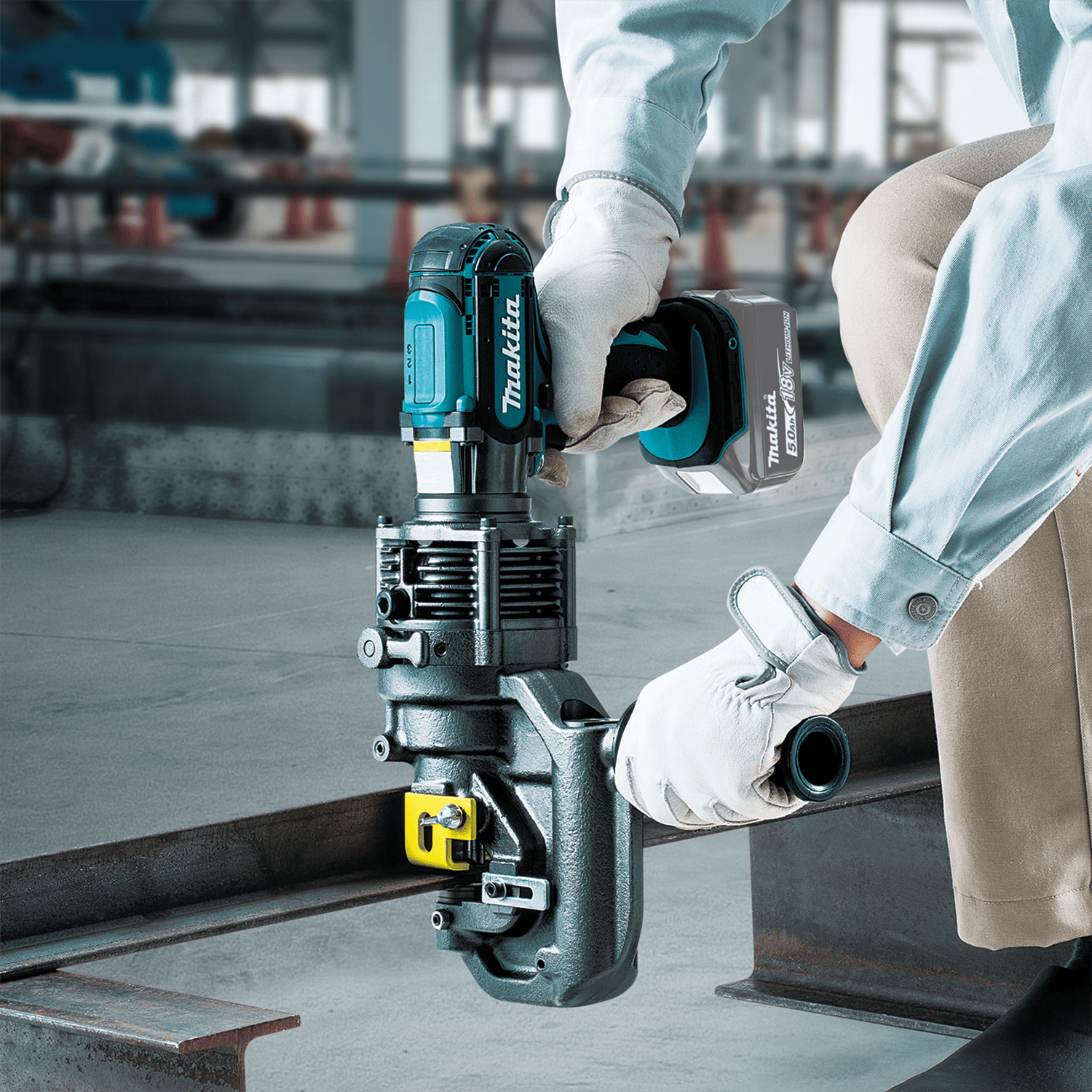 Ironworker using the Makita 18V cordless hole puncher to punch a clean hole through a structural steel beam flange.