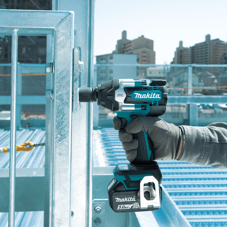 Ironworker securing structural steel frame bolts on an elevated construction site using a Makita XWT17 1/2-inch impact wrench.